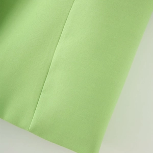 Detailed macro view of light green woven blazer fabric and high-quality stitching seams