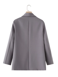 Detail view of the seamless back and sharp tailoring of a gray shawl collar blazer