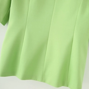 Detail view showing tailored back seams and princess line of the bright green blazer