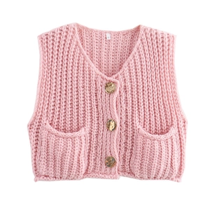 Close-up of pink chunky knit vest featuring gold embossed buttons and symmetrical pockets