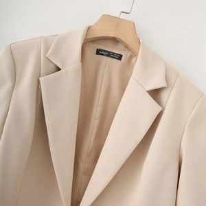 Detail of beige lapel blazer featuring smooth matching lining and premium twill fabric texture