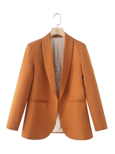 Detail of orange shawl collar blazer showing smooth twill fabric and interior lining