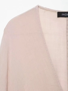 Détail d'un haut en ramie beige avec col en V montrant la texture du tissu fin