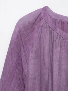 Détail de la texture en lin violet et de l'encolure plissée sur cette robe d'été légère
