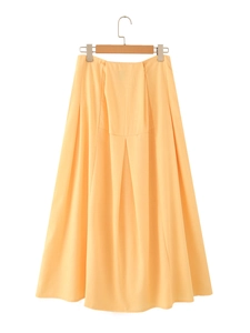 Detail of an apricot cotton-linen midi skirt featuring pleated design and metal buckle