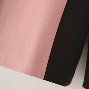 Detailed close-up showing pink twill fabric stitched with black plain weave material