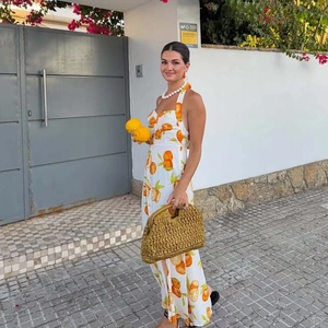 Summer halter maxi dress in white linen featuring vibrant orange fruit print patterns