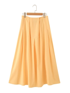 Detail of light orange pleated midi skirt featuring high-waist A-line cut and fine textures