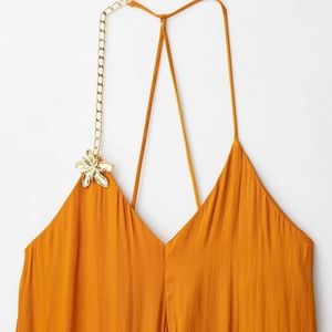 Robe midi en satin orange avec chaîne dorée asymétrique et détail de fleur en métal