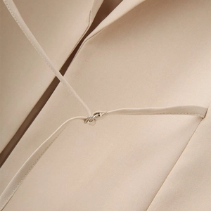 Close-up of khaki blazer strap featuring a sleek silver metal ring connector detail