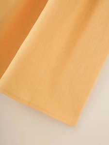 Detailed macro view of orange linen-cotton blend fabric texture with fine weave pattern