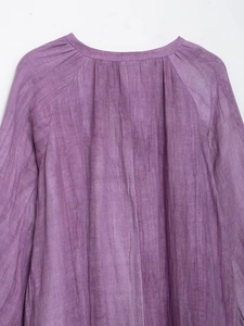 Gros plan sur l'encolure plissée et la texture lin naturel d'une robe violette