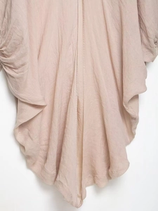 Gros plan détaillé montrant la texture plissée du tissu en ramie rose lotus fluide
