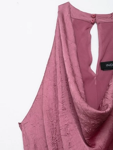 Detailed view of dusty rose pleated midi dress with halter neck and back button closure