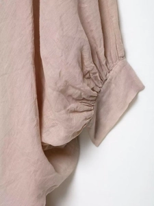 Détail du poignet en mélange de lin vieux rose avec des plis délicats et une texture