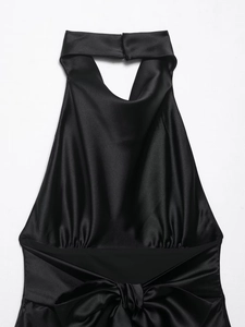 Detail of black silk halter dress with neck cutout and large decorative waist bow