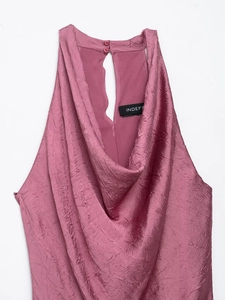 Close-up of pleated fabric and halter neck detail with back button closure on a rose pink dress
