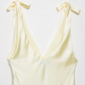 Pale yellow satin midi dress with deep V-neck and elegant bow shoulder straps