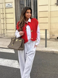 Women coarse knit sleeveless red vest sweater with large buttons on white shirt street style