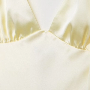 Elegant satin midi dress in pale yellow featuring a deep V-neck and pleated chest detail