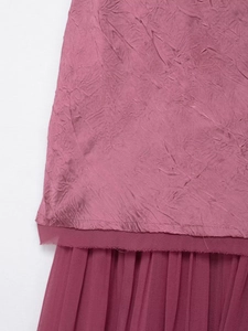 Detail of plum midi dress showing pleated chiffon layer and frayed raw edge craftsmanship