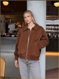 Close-up of brown suede bomber jacket with metal zipper and classic lapel collar