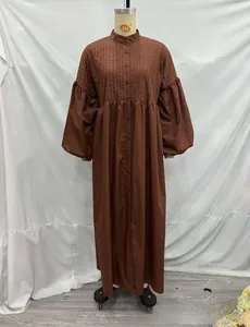 Detail of dark brown maxi dress featuring vertical pleats and single-breasted buttons