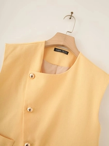 Detail of apricot linen vest with gold buttons and branded label inside the neck