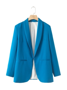 Detail of a bright blue shawl collar blazer with welt pockets and white lining