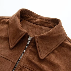 Close-up of brown faux suede bomber jacket showing metal zipper and collar texture