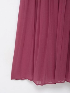 Close-up of pleated plum chiffon fabric showing detailed vertical folds and texture