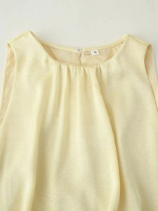 Détail de l'encolure froncée et fermeture à bouton sur robe sans manches jaune