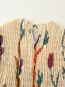 Detail of smocking texture and keyhole back button on floral cotton linen dress