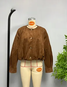Detail view of brown faux suede bomber jacket with amber buttons and elastic hemline