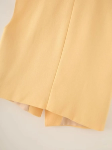 Macro shot of yellow vest back hem with woven texture and smooth inner lining