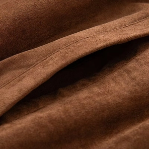 Macro shot of dark brown faux suede fabric showing premium stitching and soft matte texture