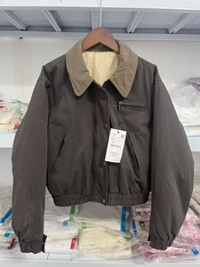 Detail of dark brown workwear jacket with khaki corduroy collar and zip pocket