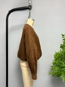 Detail view of a loose-fit dark brown suede bomber jacket on a mannequin torso