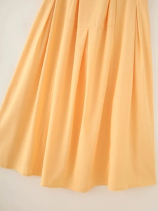 Detail of apricot cotton linen midi skirt showing pleated texture and breathable fabric