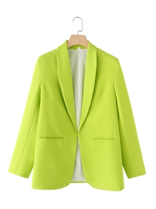 Detail of neon green blazer showing shawl collar, flat pockets and smooth suit fabric