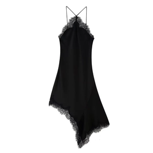 Détail d'une robe en satin noir avec bordure en dentelle et ourlet asymétrique