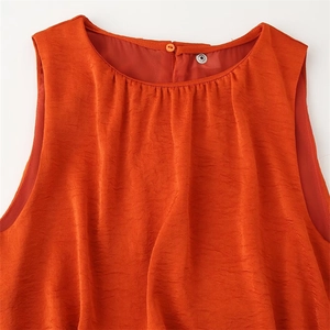Détail de l'encolure plissée et de la fermeture à bouton au dos d'une robe sans manches