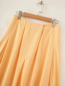 Detailed texture of cotton linen pleated midi skirt in apricot with high waist design