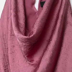 Elegant midi dress with pleated texture and draped neckline in a dusty rose pink shade