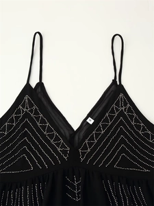Close-up of black V-neck camisole featuring silver beaded geometric patterns and fine straps