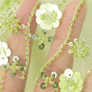Sheer light green mesh fabric with floral sequin embroidery and beadwork decoration