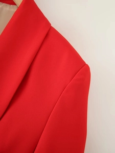 Close-up of a red shawl collar blazer showing premium fabric texture and shoulder stitching