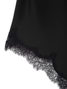 Détail de dentelle de cils noire et motif floral sur l'ourlet d'une robe en satin