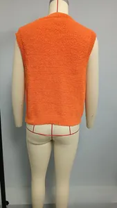 Rear view of an orange waffle knit sleeveless vest on a mannequin with ribbed hem