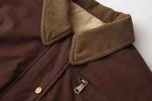 Detailed view of dark brown jacket with corduroy collar and vintage brass snap buttons